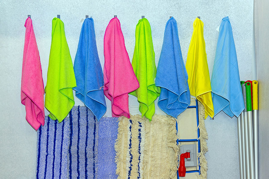 Colour coded cleaning cloths hanging on the wall