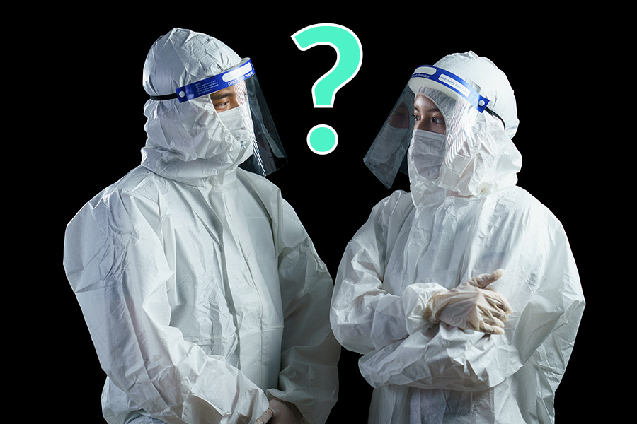 Two people wearing PPE with a question mark between them