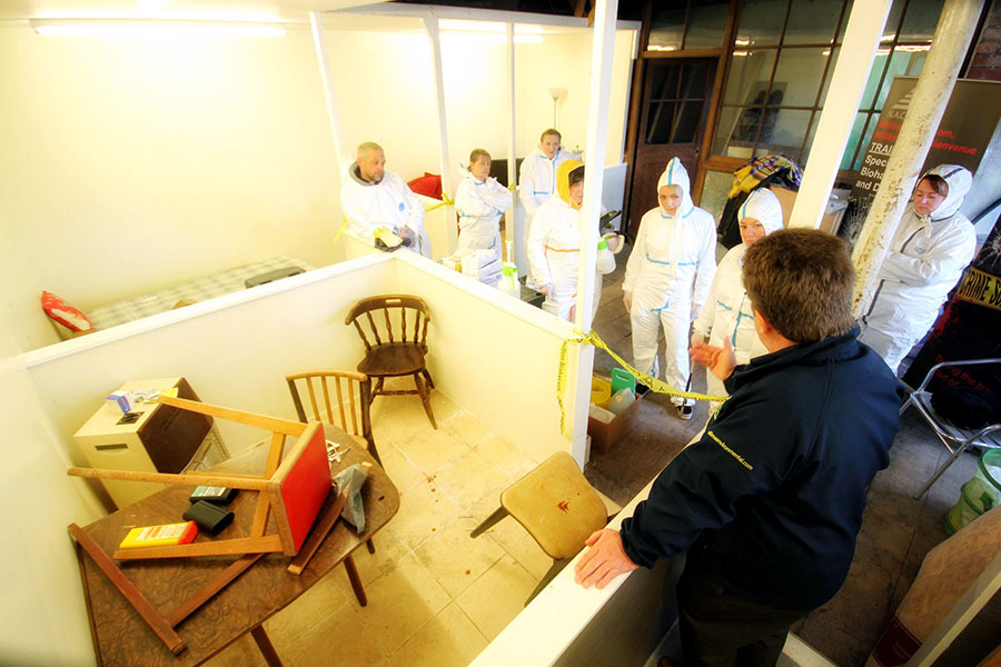 A group of Ultima Cleaning Academy students having a mock crime scene explained to them